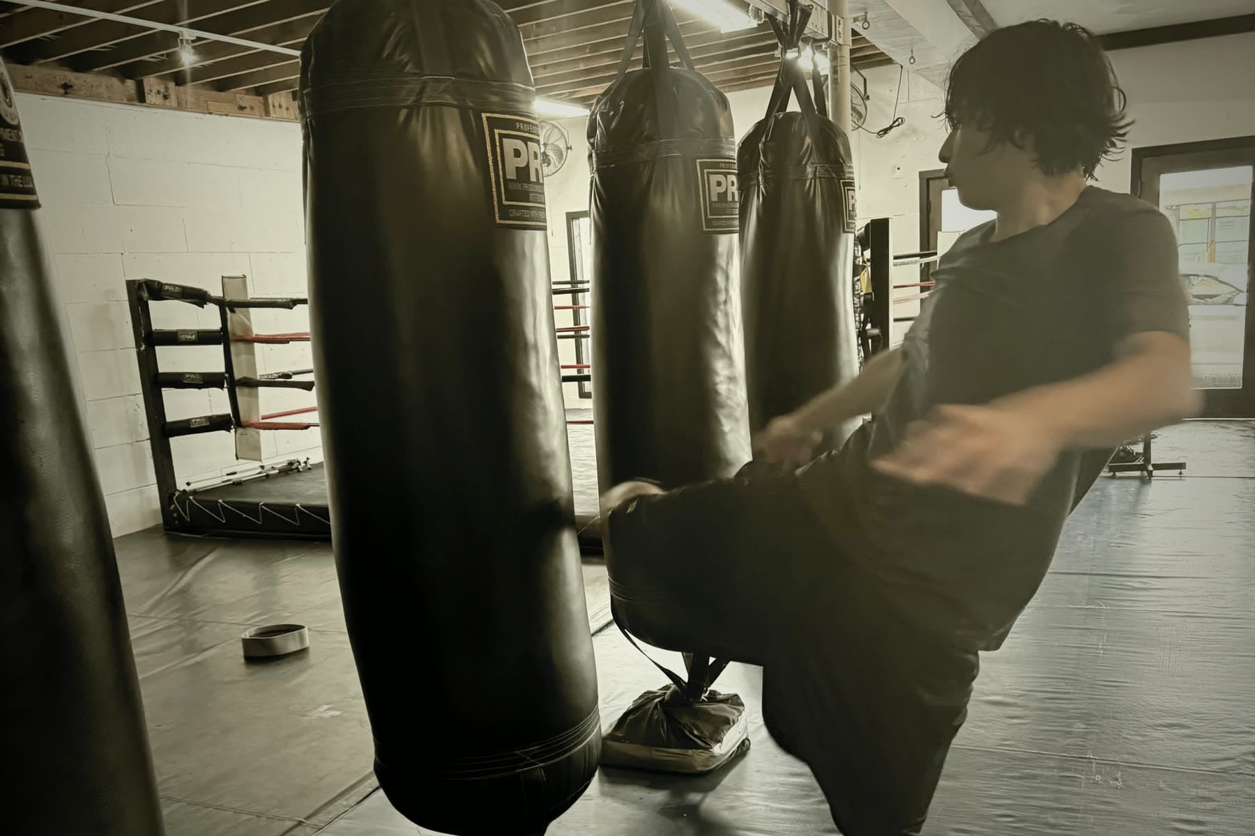 A fighter working a heavy bag on the training floor at JFM Boxing in Venice